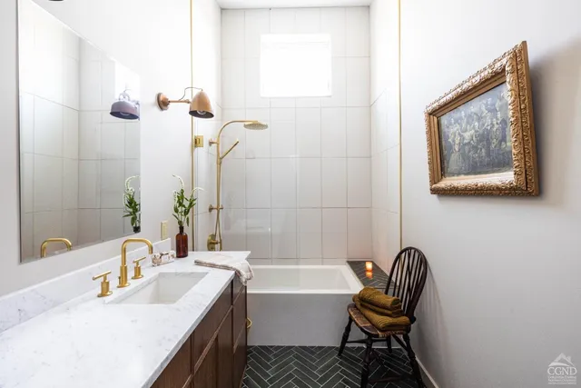 a bathroom with a tub sink and mirror