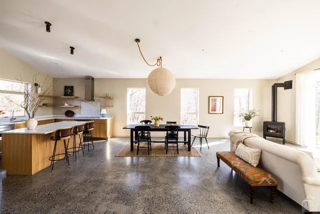 a living room with furniture kitchen view and a large window