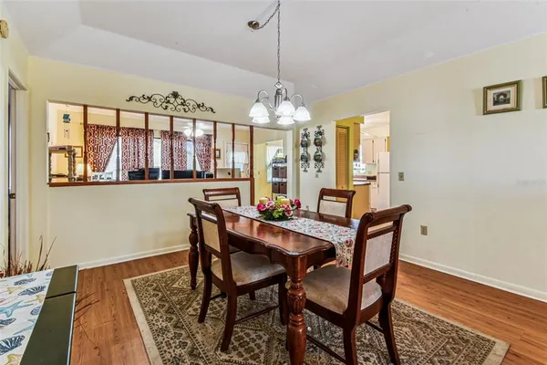 a dining room with furniture a chandelier and wooden floor