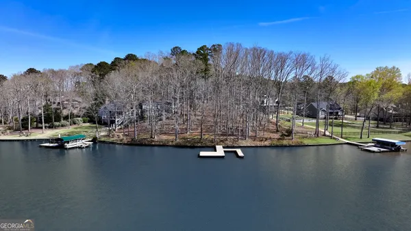 a view of swimming pool with outdoor seating and trees in the background