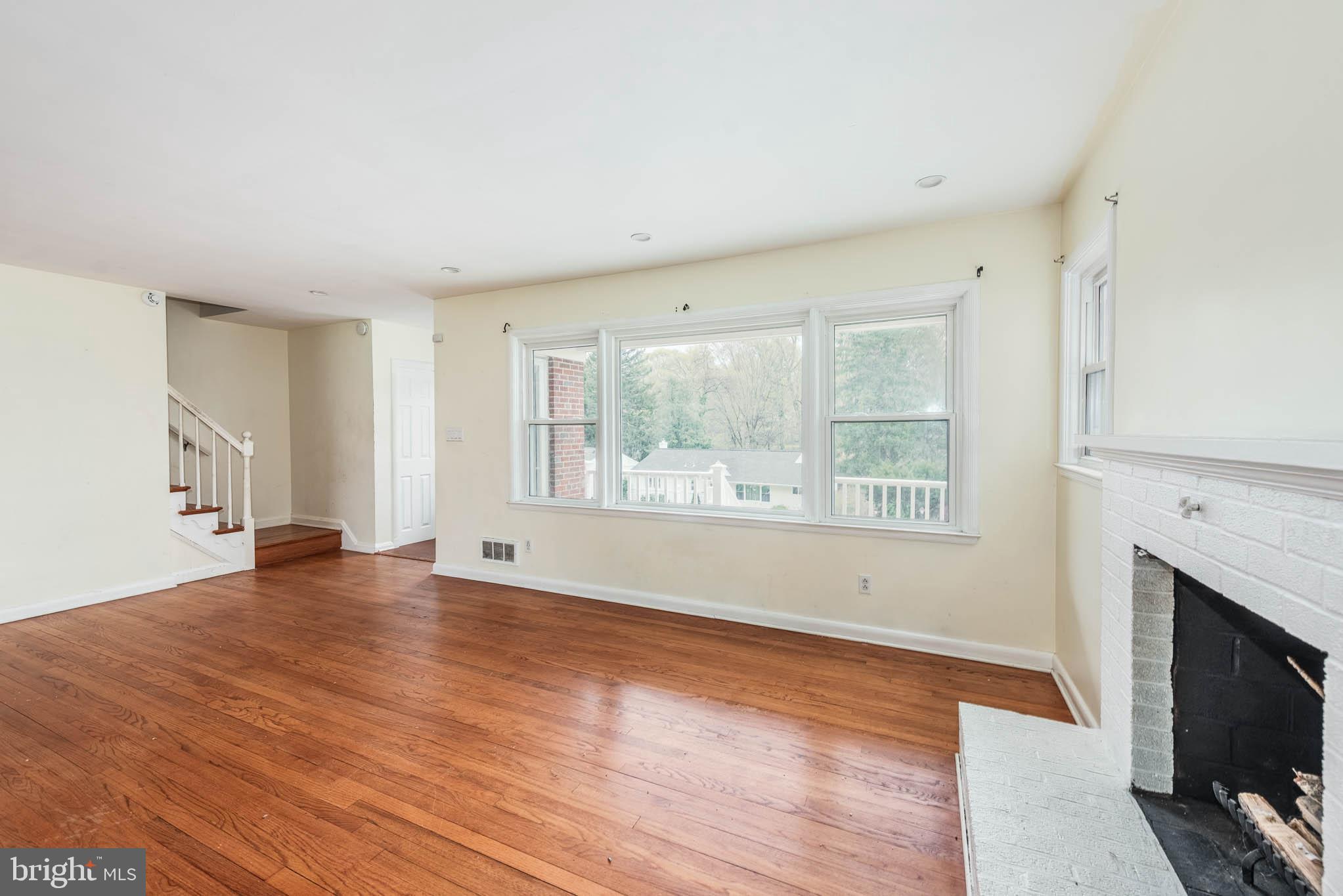 6702 Queens Ferry Road Baltimore, MD 21239 - Photo 3 of 40 a view of an empty room with wooden floor and a window