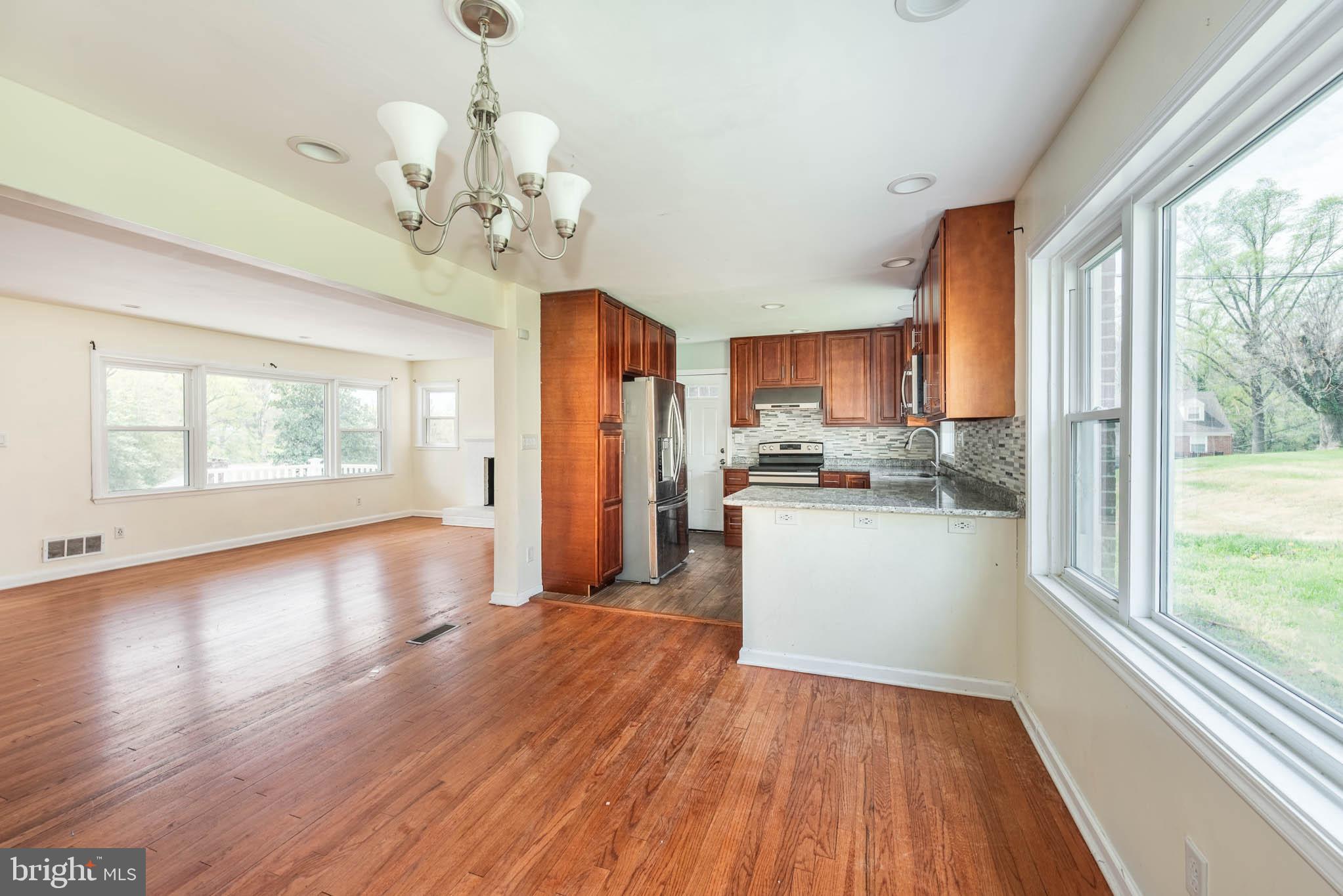 6702 Queens Ferry Road Baltimore, MD 21239 - Photo 6 of 40 a kitchen with stainless steel appliances granite countertop wooden floors and window