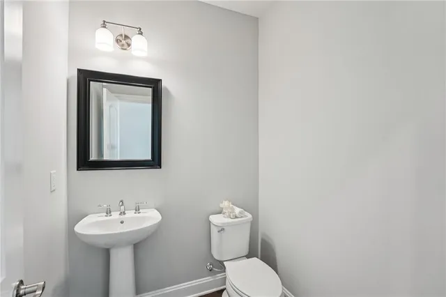 a kitchen with granite countertop a stove a sink and a white cabinets with wooden floor