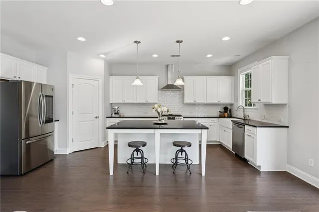 a kitchen with a refrigerator and white cabinets