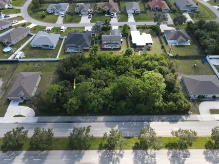 an aerial view of residential houses with outdoor space and parking
