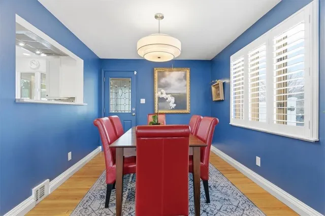 a dining room with furniture a chandelier and wooden floor