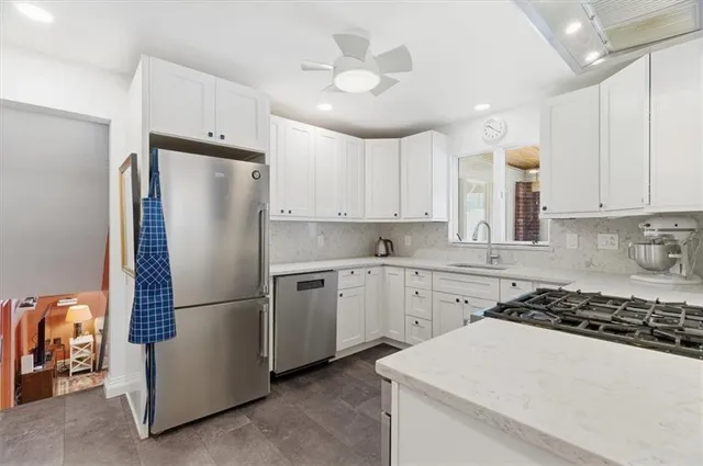 a kitchen with a refrigerator a sink and cabinets