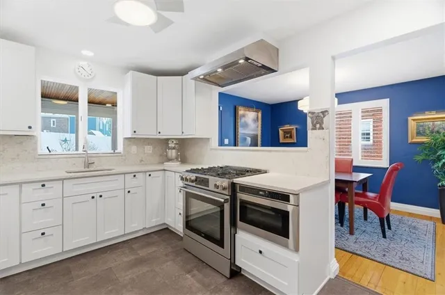 a kitchen with granite countertop white cabinets and white appliances