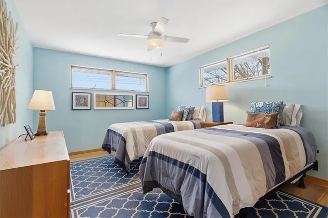 a bedroom with two beds and wooden floor
