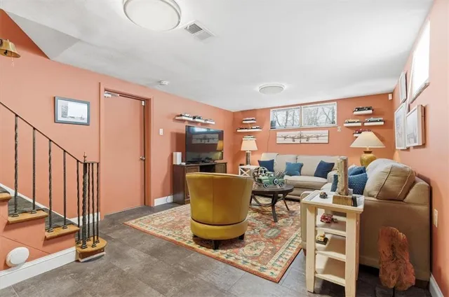 a living room with furniture a flat screen tv and a window
