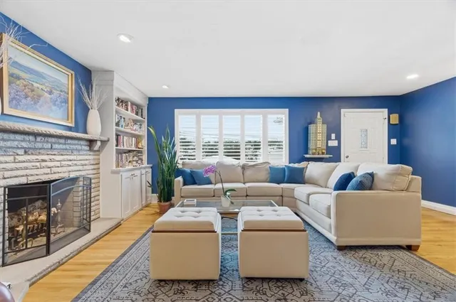 a living room with furniture a fireplace and a large window