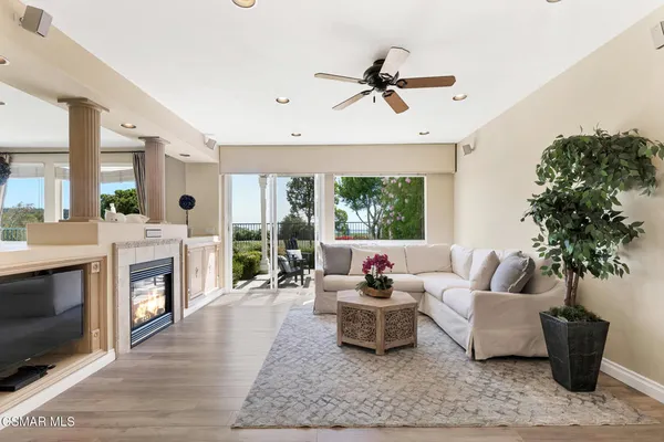 a view of a room with wooden floor and a ceiling fan