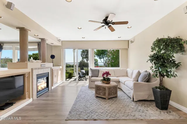 a view of a room with wooden floor and a ceiling fan