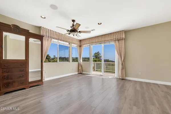 a view of a big room with wooden floor and windows