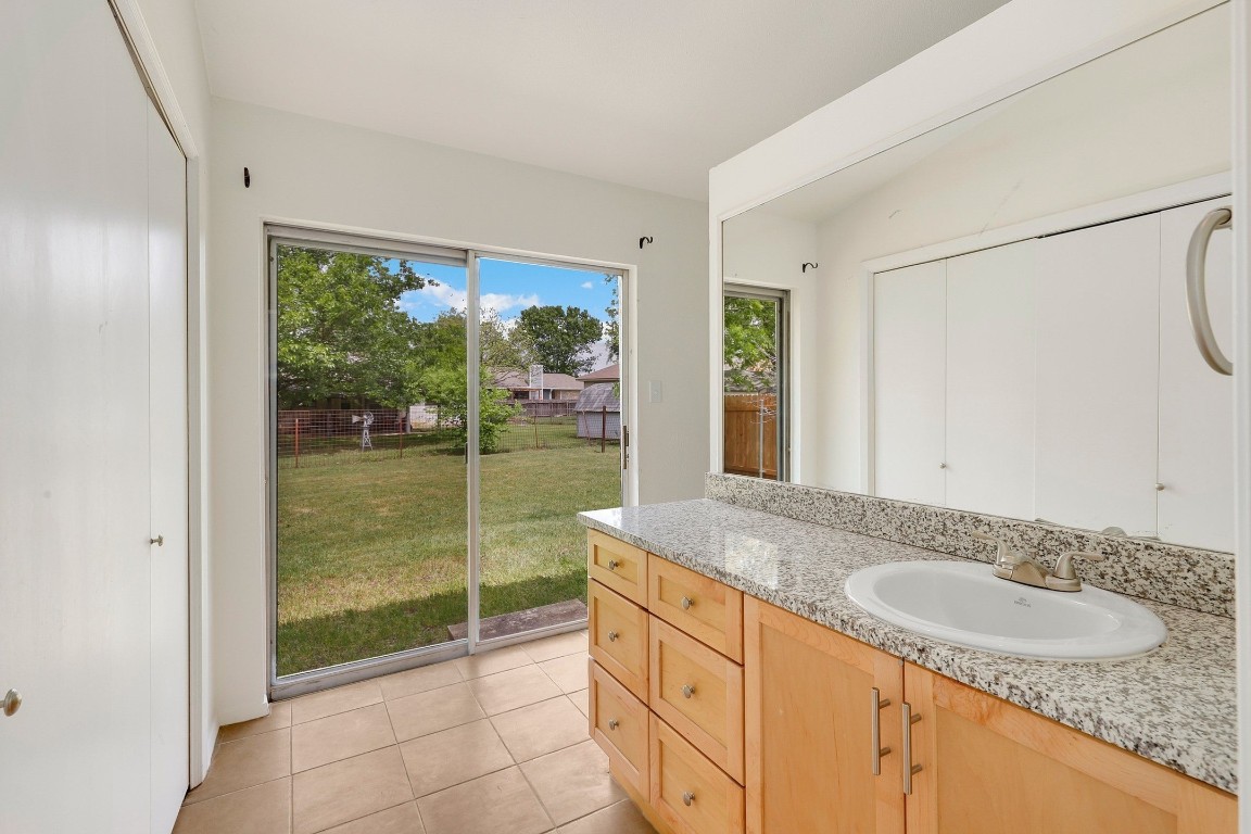 1008 Ridgeline Drive Round Rock, TX 78664 - Photo 20 of 30 a bathroom with a granite countertop sink and a mirror