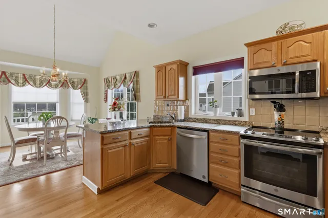 a kitchen with stainless steel appliances granite countertop a stove a sink and a microwave