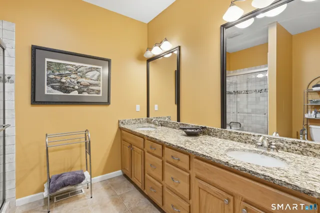 a bathroom with a granite countertop sink and a mirror