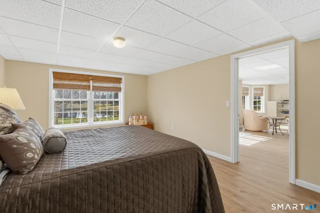 a view of a bedroom with a bed and wooden floor
