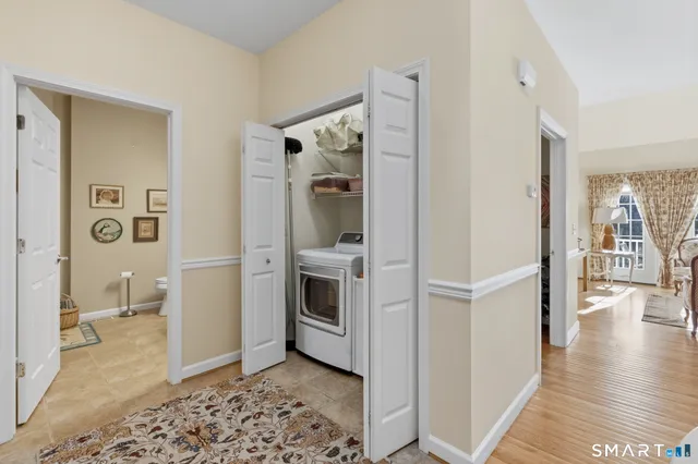 a view of a hallway with bathroom and wooden floor