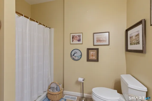 a white toilet sitting next to a bathroom and a shower curtain