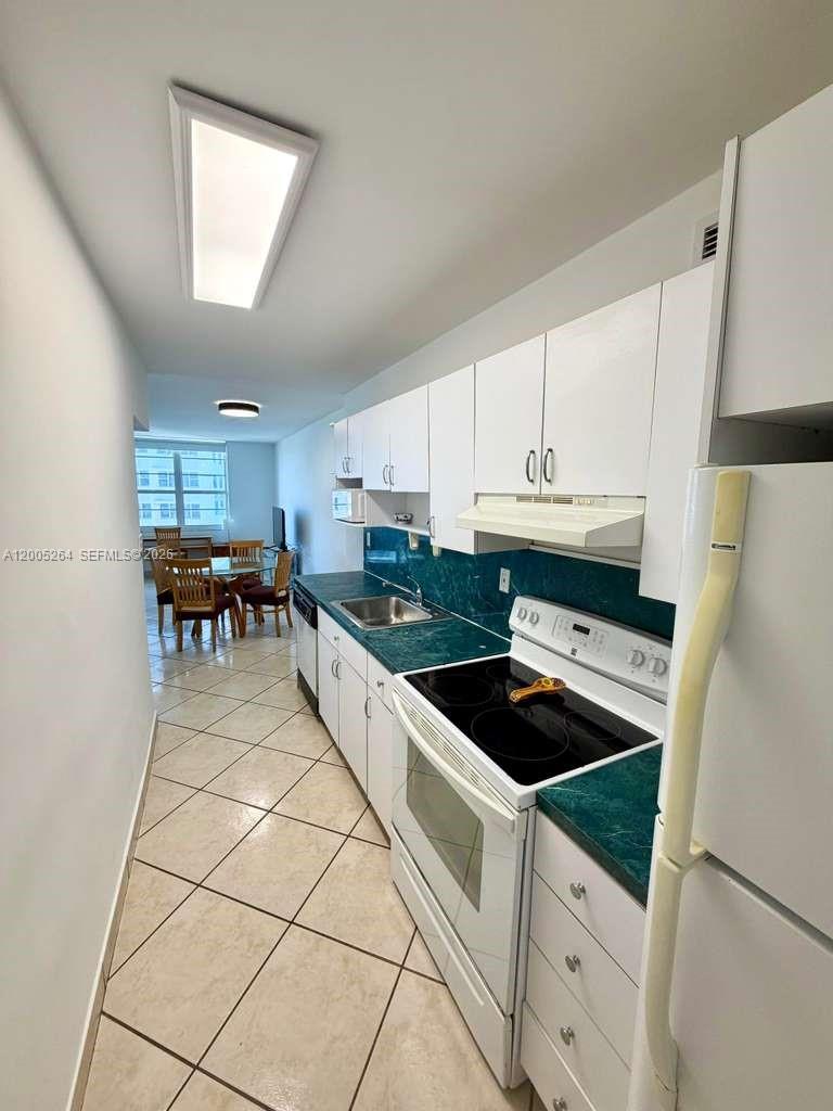 100 Lincoln Road, Unit 731 Miami Beach, FL 33139 - Photo 8 of 12 a kitchen with granite countertop a refrigerator and a stove top oven