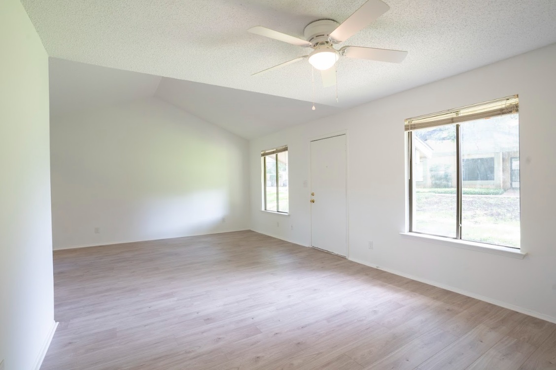 906 Silver Quail Lane Austin, TX 78758 - Photo 11 of 33 Spare room featuring light wood-style floors, vaulted ceiling, a textured ceiling, and a ceiling fan