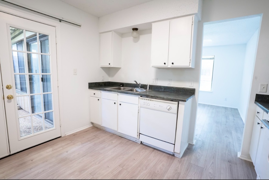 906 Silver Quail Lane Austin, TX 78758 - Photo 12 of 33 Kitchen featuring white cabinetry, dishwasher, dark countertops, light wood-style flooring, and plenty of natural light