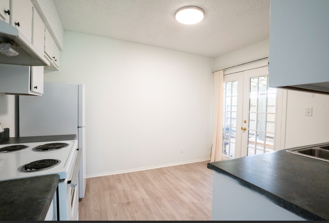 906 Silver Quail Lane Austin, TX 78758 - Photo 14 of 33 Kitchen with electric stove, dark countertops, white cabinetry, a textured ceiling, and french doors