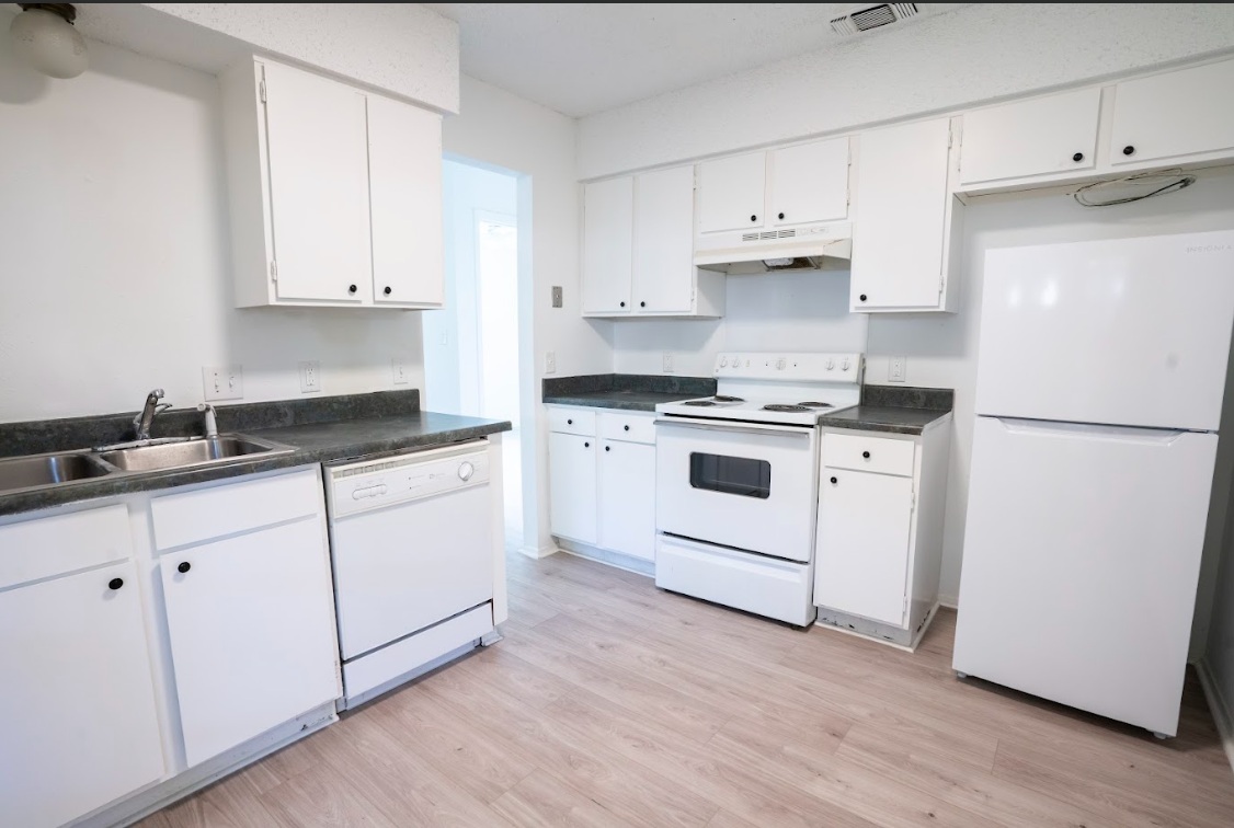 906 Silver Quail Lane Austin, TX 78758 - Photo 15 of 33 Kitchen with white appliances, dark countertops, and white cabinets