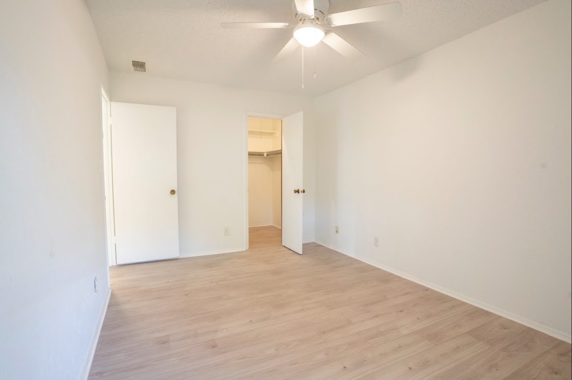 906 Silver Quail Lane Austin, TX 78758 - Photo 20 of 33 Unfurnished bedroom with light wood-style flooring, a walk in closet, and ceiling fan