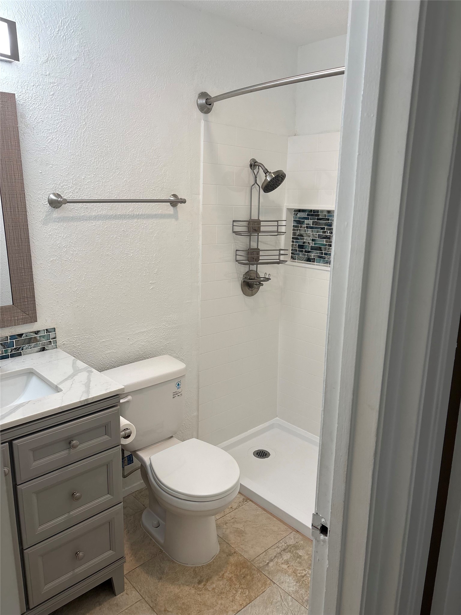 906 Silver Quail Lane Austin, TX 78758 - Photo 22 of 33 Bathroom with vanity, a textured wall, and a stall shower