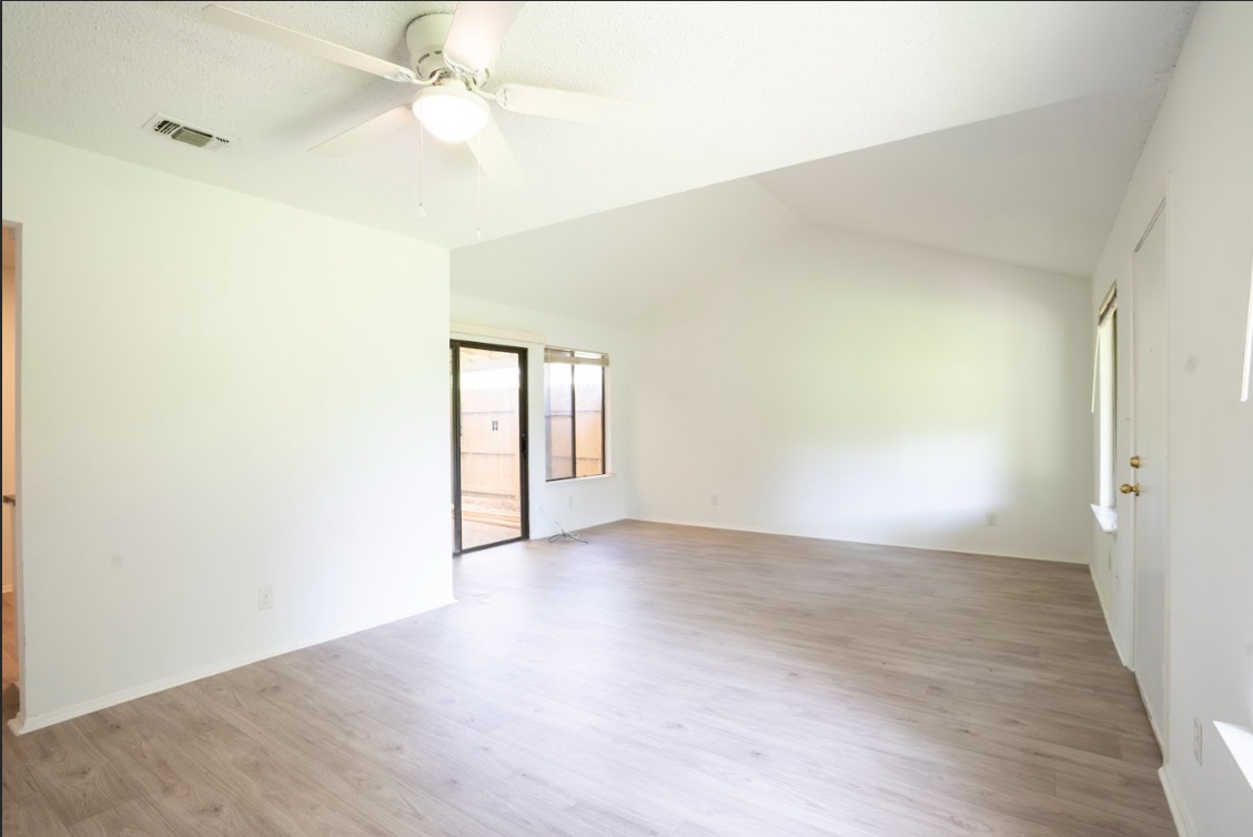 906 Silver Quail Lane Austin, TX 78758 - Photo 9 of 33 Unfurnished room with light wood-type flooring, lofted ceiling, and a ceiling fan