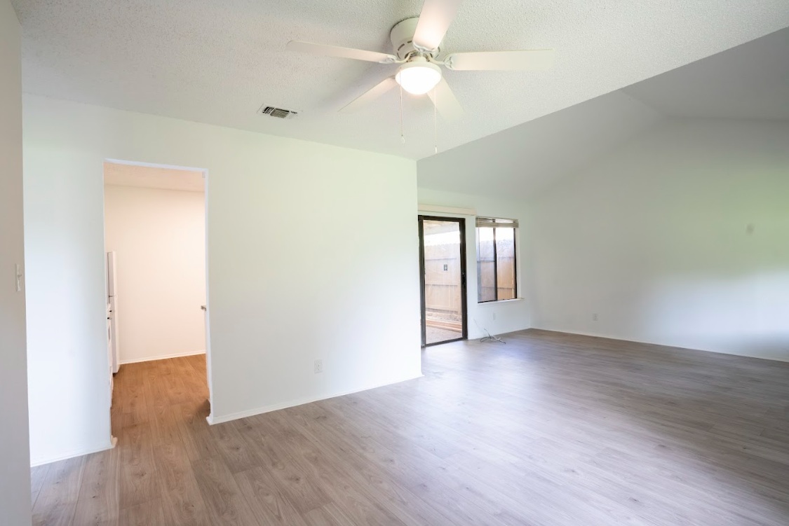 906 Silver Quail Lane Austin, TX 78758 - Photo 10 of 33 Unfurnished room with light wood-type flooring, vaulted ceiling, and a ceiling fan