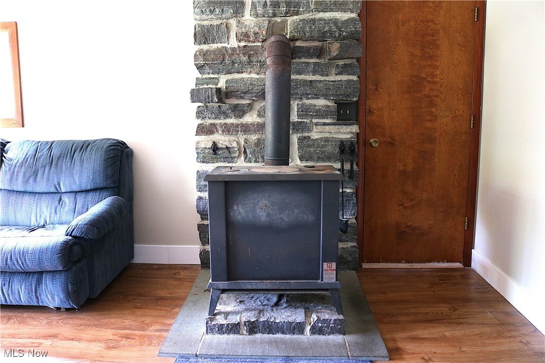 14485 Bass Lake Road Newbury, OH 44065 - Photo 14 of 22 Detailed view of a wood stove and wood finished floors