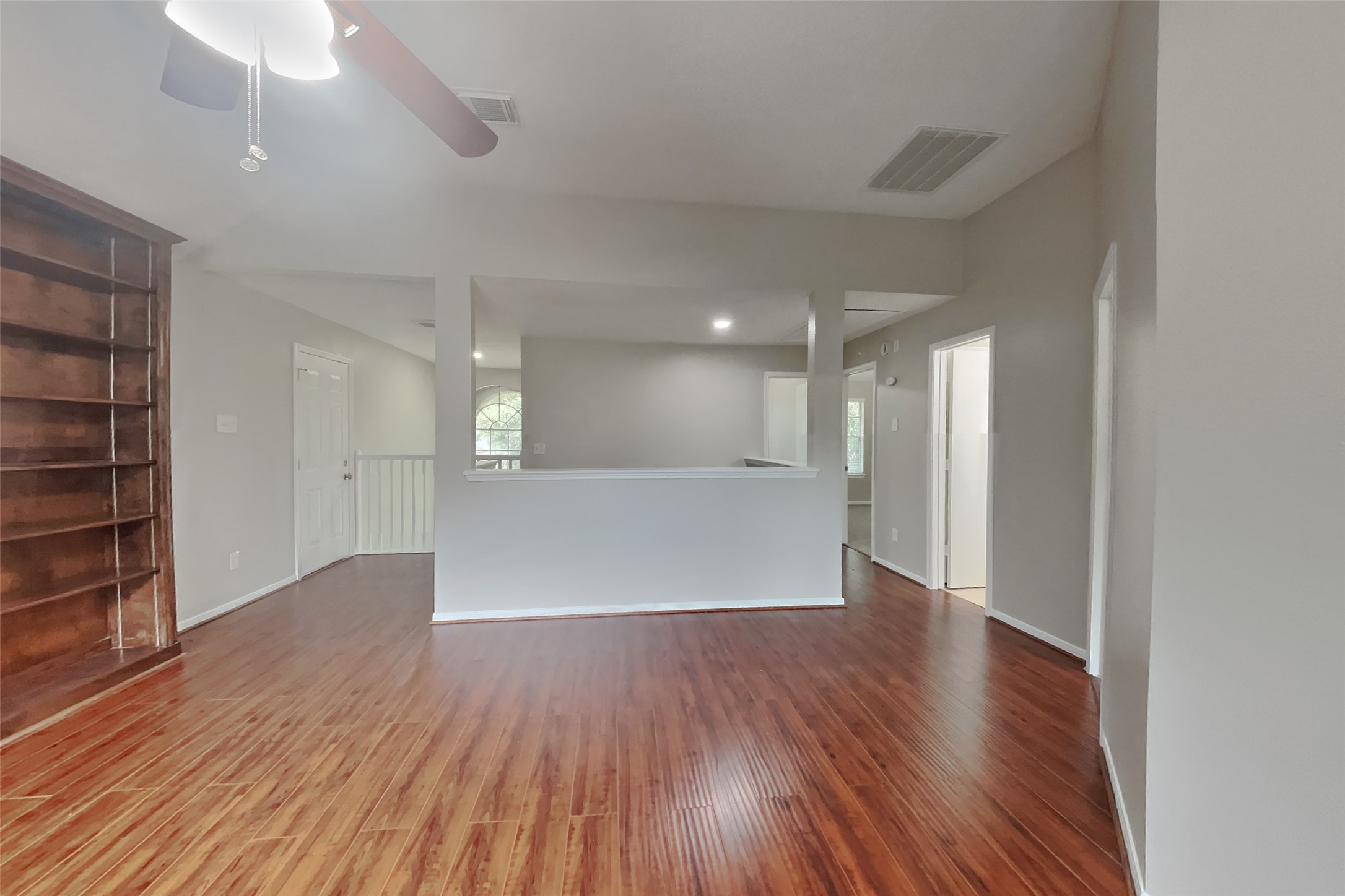 619 Bending Bough Drive Spring, TX 77388 - Photo 18 of 22 a view of an empty room with wooden floor and a kitchen