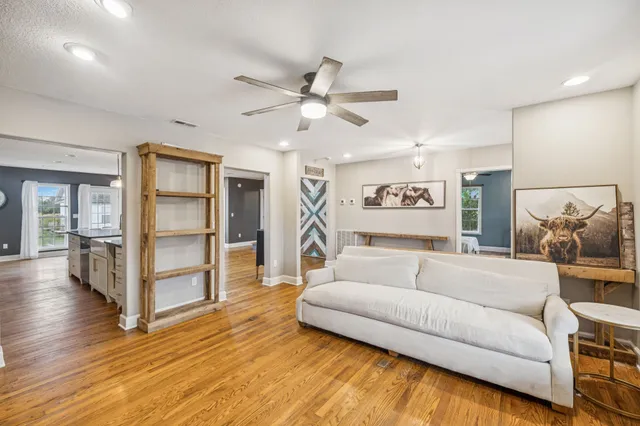 a living room with furniture and a wooden floor