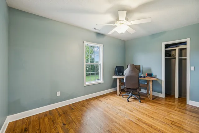 a spacious bedroom with a bed a fireplace and a chandelier