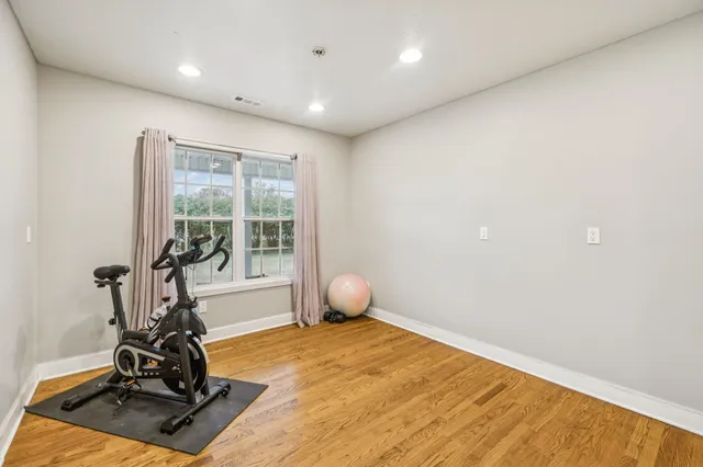 a view of a house with a yard and a large tree