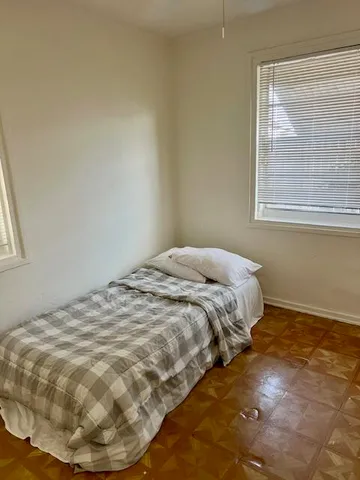 a bed sitting in a bedroom next to a window