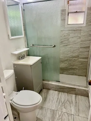 a bathroom with a sink a toilet and shower