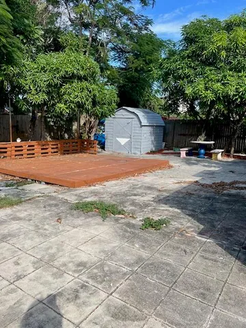 a view of a yard with plants and trees