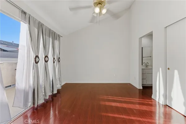 a view of an empty room with window and wooden floor
