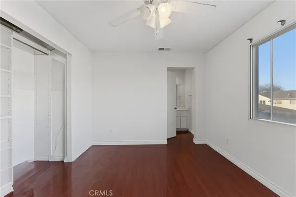 an empty room with wooden floor cabinet and closet