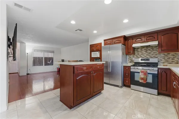 a kitchen with stainless steel appliances granite countertop a refrigerator and a stove