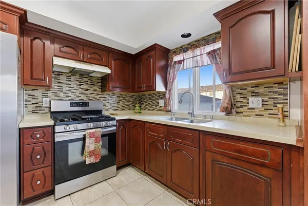 a kitchen with stainless steel appliances granite countertop a sink stove and cabinets