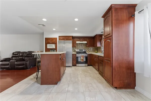 a kitchen with stainless steel appliances granite countertop a refrigerator and a stove