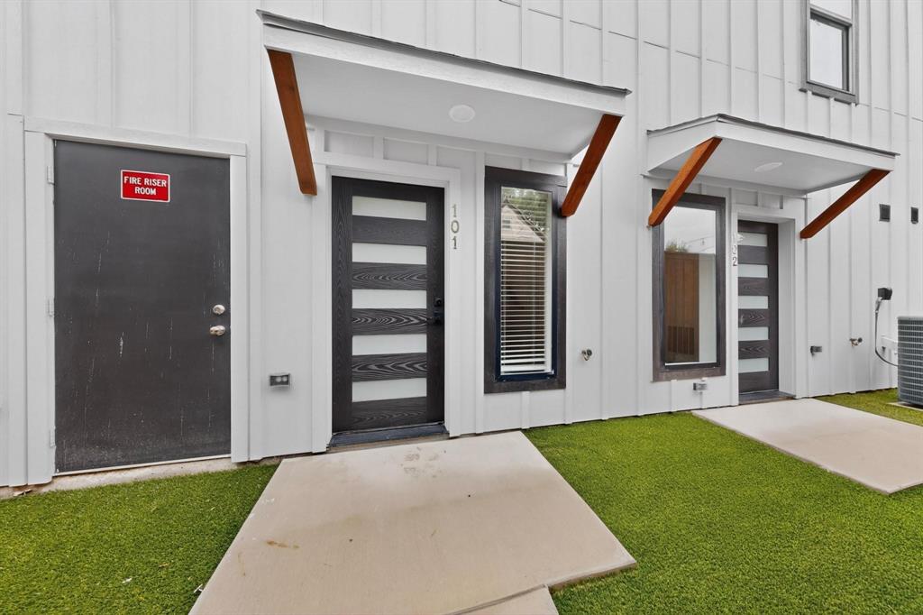 2226 Shea Road, Unit 103 Dallas, TX 75235 - Photo 2 of 35 Exterior featuring white vertical panel siding and architectural canopies with wood supports