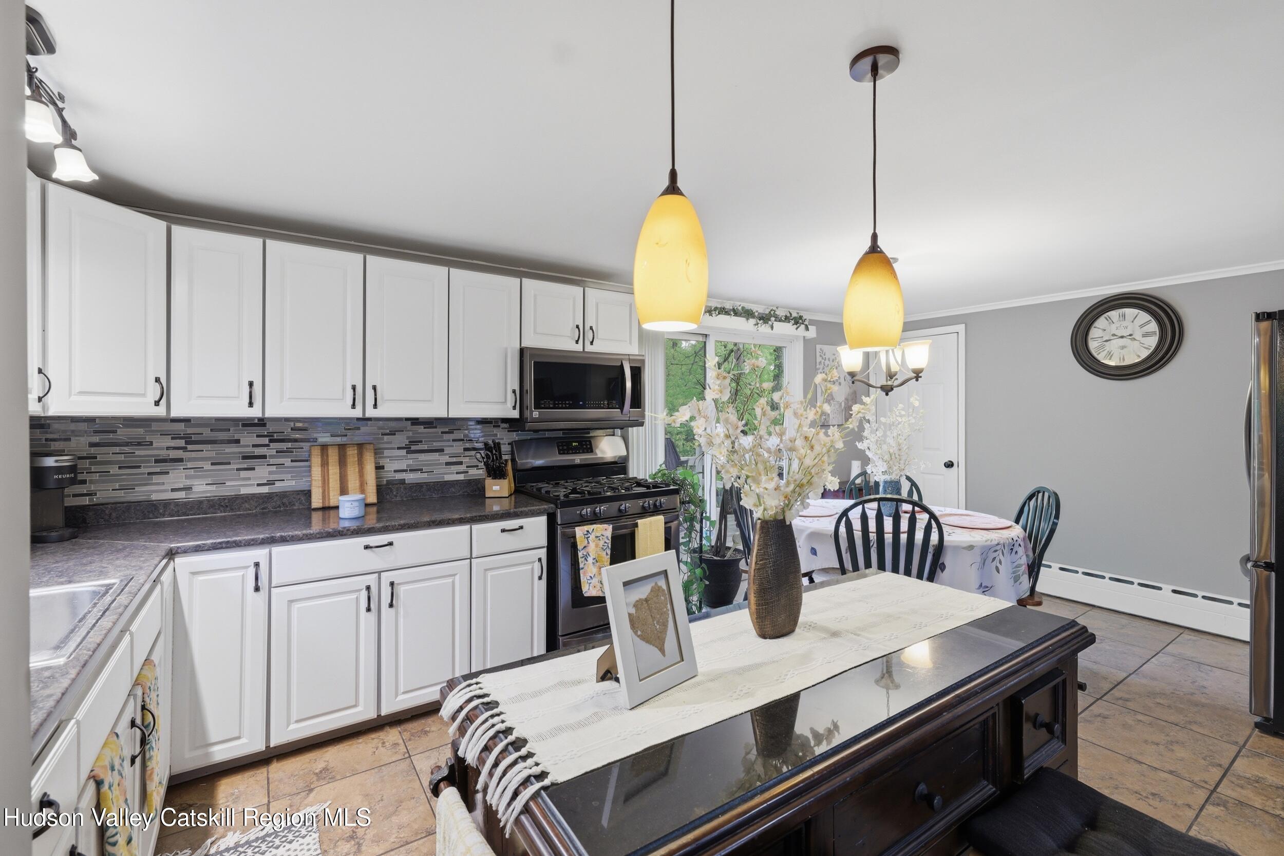 186 Cedar Hill Road High Falls, NY 12440 - Photo 11 of 33 a kitchen with stainless steel appliances kitchen island granite countertop a sink a stove and a wooden floors