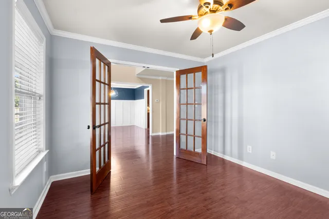 a large kitchen with stainless steel appliances granite countertop a refrigerator stove top oven a sink a dining table and chairs with wooden floor