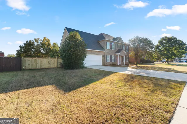 a view of a brick house with many windows next to a yard